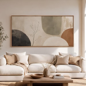 Puede incluir: Una gran pieza de arte mural enmarcada de forma rectangular que presenta formas abstractas en tonos apagados de carbón, verde salvia y terracota sobre un fondo crema, con un delicado dibujo de líneas negras de una rama.