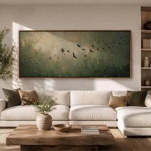 Puede incluir: Una gran pieza de arte mural rectangular que presenta un paisaje abstracto en tonos verde salvia, oliva y crema, representando una bandada de aves en vuelo sobre un fondo texturizado y pictórico, enmarcada en un borde fino de madera natural.