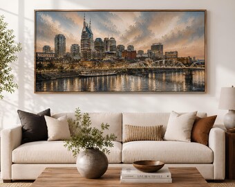 May include: A large rectangular wall art print depicting the Nashville skyline at sunset, featuring the AT&T Building, the Cumberland River, and the John Seigenthaler Pedestrian Bridge, with warm orange and blue sky tones reflected in the water.