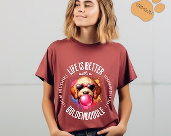 Può includere: T-shirt bordeaux con grafica di un Goldendoodle con occhiali da sole a forma di cuore e che soffia una bolla. Il testo "LIFE IS BETTER with a GOLDENDOODLE" è stampato intorno al cane. Girocollo.