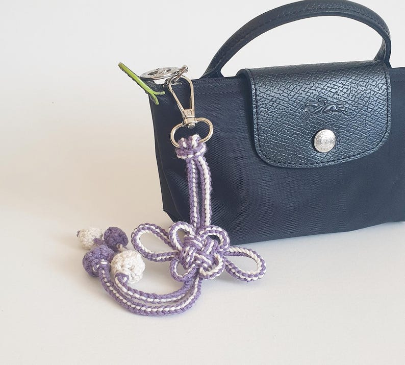 Handmade lavender Korean knot bag charm attached to navy handbag