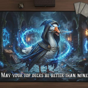 May include: A black gaming mousepad featuring a goose dressed as a wizard, holding a dagger, surrounded by blue energy. The text "MAY YOUR TOP DECKS BE BETTER THAN MINE." is at the bottom. Includes a fantasy castle background.
