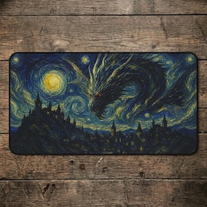 May include: A rectangular desk mat featuring a dark blue and yellow swirling night sky with a large dragon silhouette soaring above a silhouetted town with tall spires and glowing yellow windows, rendered in a textured, painterly art style.