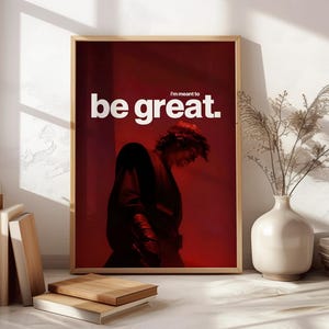 May include: A rectangular framed wall art print featuring a dark red background with a silhouette of a person in a tunic. The text "I'm meant to" appears in small white letters above the large, bold white text "be great." centered at the top.