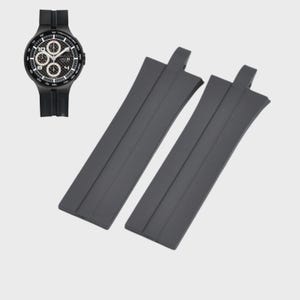 May include: A black wristwatch with a round face and multiple sub-dials, paired with two black watch straps. The watch features a black bezel and a black band. The watch straps are made of a flexible material.