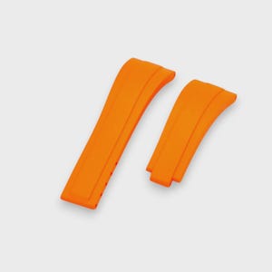 May include: Two bright orange watch straps. The straps are made of a flexible material and have a curved design. The straps are shown against a white background.