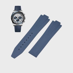 May include: A wristwatch with a silver case, white face, and blue subdials, paired with a blue silicone watch band. Two additional blue silicone watch straps are also displayed, showcasing a textured pattern.