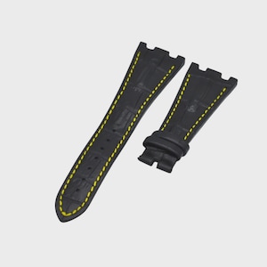 May include: Black watch strap with yellow stitching. The strap is made of a textured material and has a classic design. The strap is designed to fit a watch.