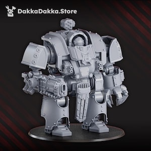 Puede incluir: Un robot en miniatura gris detallado, con un brazo de arma y un brazo de garra, de pie sobre una base circular negra. El robot tiene una cabina y múltiples componentes mecánicos. El texto "DakkaDakka.Store" es visible.