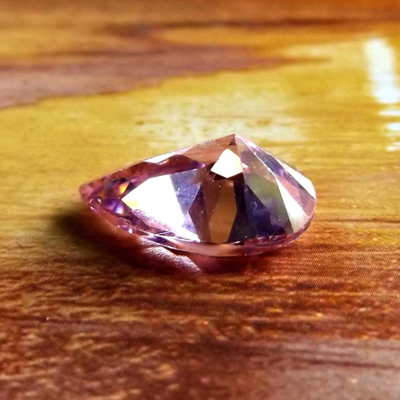 Face down in a wet sandy sea setting, showing the pointy back, ready to be made into jewelry