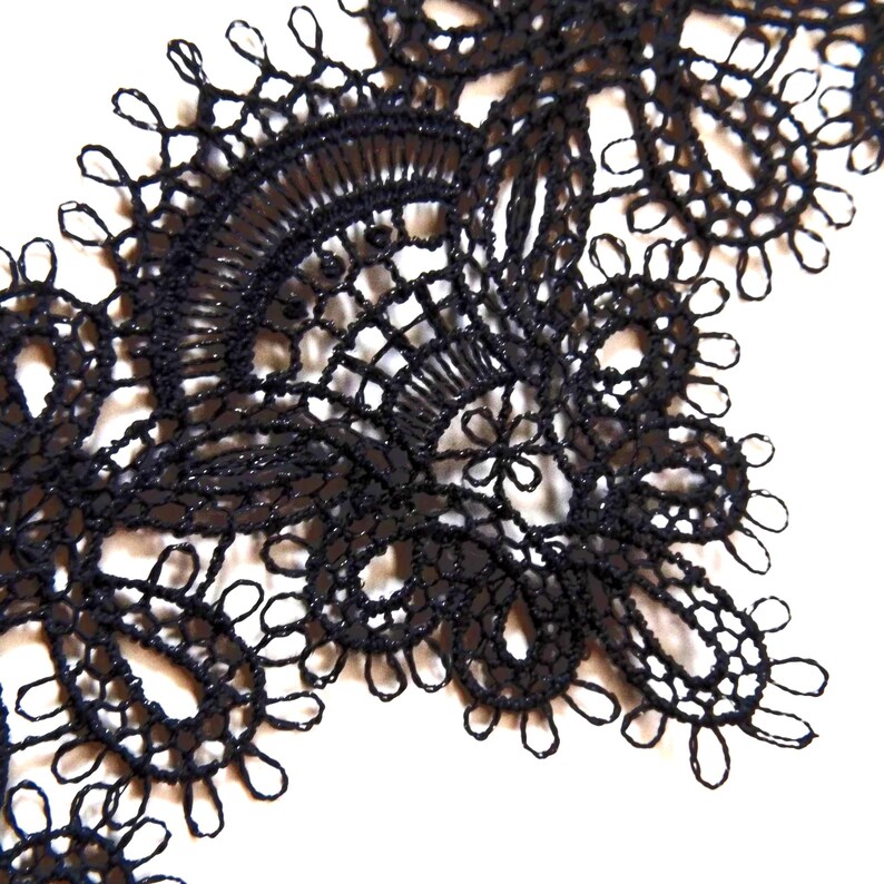 Close-up of black choker made of fine embroidery lace with metal hook and figaro chain closure.