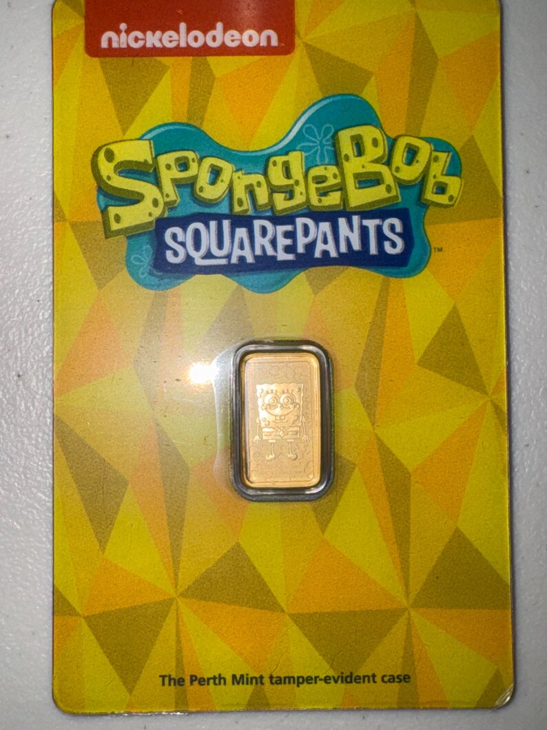 May include: A gold bar featuring SpongeBob SquarePants in a tamper-evident case. The packaging is yellow with a geometric pattern and the Nickelodeon and SpongeBob SquarePants logos. The text "The Perth Mint tamper-evident case" is visible.