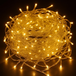 Puede incluir: Una cadena enrollada de luces de hadas LED blancas cálidas. Las luces están agrupadas, creando un efecto suave y brillante sobre un fondo oscuro. Ideal para iluminación decorativa.