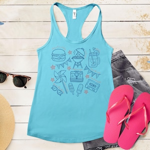 A turquoise tank top with various summer-themed icons and illustrations, including a hamburger, grill, sunglasses, flip flops, and a straw, all arranged on a wooden surface.