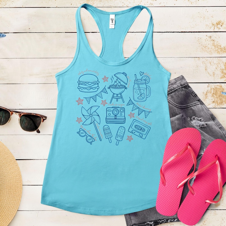 A turquoise tank top with various summer-themed icons and illustrations, including a hamburger, grill, sunglasses, flip flops, and a straw, all arranged on a wooden surface.