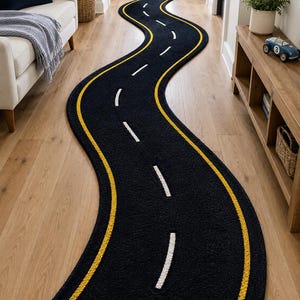 以下が含まれることがあります： 道路の形をした長く曲がりくねったランナーラグ。ラグは黒色で、端に沿って2本の黄色い実線があり、中央には破線の白い線があり、高速道路や道路の車線標示の外観を模しています。