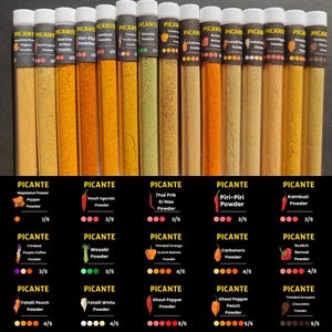 Puede incluir: Una colección de polvos de especias en tubos transparentes, etiquetados como "PICANTE". Los polvos varían en color, desde el amarillo hasta el naranja y el marrón. Cada tubo está etiquetado con el tipo de polvo de pimienta, como "Nepalese Flower Pepper Powder".