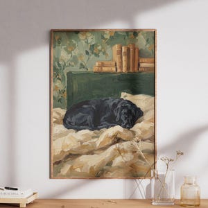 Może przedstawiać: Oprawiony obraz przedstawiający czarnego labradora śpiącego na łóżku. Łóżko ma kremową kołdrę i poduszki. Tło przedstawia zielone wezgłowie, kwiatową tapetę i książki.