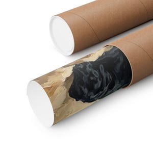A lifestyle photo of a person holding the unframed black Labrador art print, showing its actual physical scale and vibrant print quality.