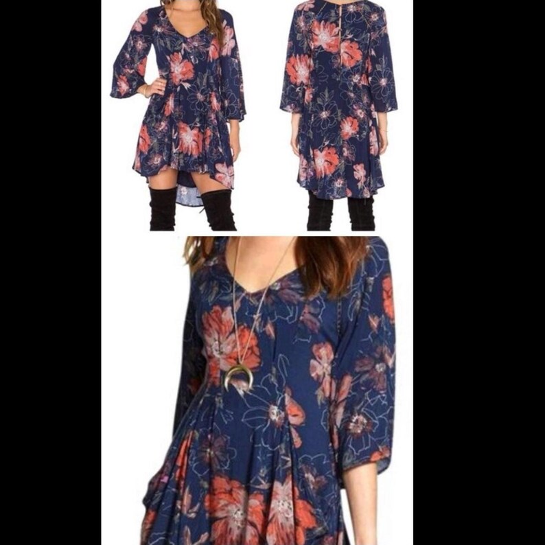 K&ouml;nnte beinhalten: Ein marineblaues Kleid mit floralem Muster. Das Kleid hat einen V-Ausschnitt, lange, ausgestellte &Auml;rmel und einen High-Low-Saum. Es ist mit gro&szlig;en orangefarbenen und wei&szlig;en Blumen verziert.