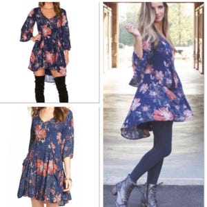 K&ouml;nnte beinhalten: Ein marineblaues Kleid mit rosa und wei&szlig;en Blumenmuster. Das Kleid hat einen V-Ausschnitt und ausgestellte &Auml;rmel. Der Saum ist asymmetrisch. Das Kleid ist knielang. Geeignet f&uuml;r verschiedene Anl&auml;sse.
