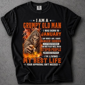 May include: A black short-sleeve t-shirt featuring a graphic of a brown Bigfoot pointing forward surrounded by orange flames. The text reads: I AM A GRUMPY OLD MAN I WAS BORN IN JANUARY I HAVE ANGER ISSUES & A THIN PATIENCE I DO NOT PLAY WELL WITH STUPID PEOPLE AND CUSS TOO MUCH I'M LIVING MY BEST LIFE YOUR APPROVAL ISN'T NEEDED.