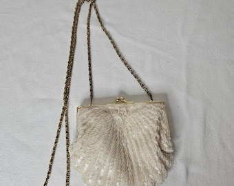 Bolsa transversal La Regale Vintage com contas e detalhes em concha, corrente branca iridescente com detalhes em ouro.