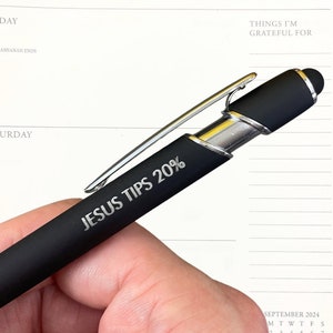 Może przedstawiać: Czarne pióro z srebrnym klipsem i końcówką do ekranów dotykowych. Na piórze wygrawerowano napis "JESUS TIPS 20%".