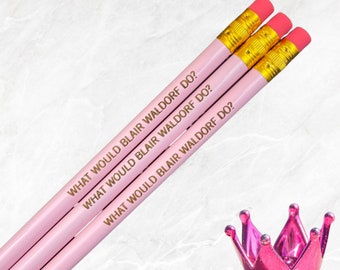 May include: Three pink pencils with gold lettering that reads "What would Blair Waldorf do?"  The pencils are stacked on top of each other.
