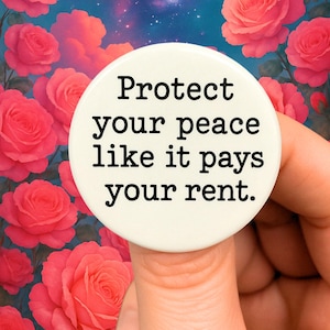 May include: White button with black text that reads "Protect your peace like it pays your rent."
