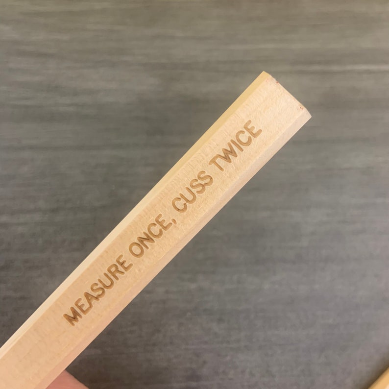 May include: A wooden ruler with the text "MEASURE ONCE, CUSS TWICE" engraved on it.