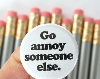 go annoy someone else. 1.25 inch funny pinback button. irritant repellent.