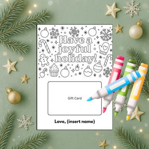 May include: A white gift card with the text "Have a joyful holiday!" and holiday-themed illustrations. The card has a space for a gift card and a line for "Love, (insert name)." Colorful markers are next to the card.