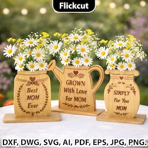 Puede incluir: Tres jarrones de flores de madera con arreglos de margaritas y flores amarillas. Los jarrones tienen forma de tarro, regadera y jarrón. El texto en los jarrones dice "Best MOM Ever", "Grown With Love For MOM" y "SIMPLY For You MOM".