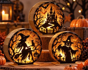 May include: Three circular wooden light boxes featuring intricate laser-cut Halloween silhouettes. The designs include a haunted castle with bats, a witch with a cat on a broomstick, and a scarecrow figure, all illuminated from within.