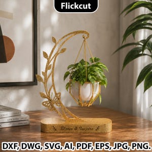 Puede incluir: Un soporte de metal dorado para plantas con un diseño de mariposa y hojas, que sostiene una maceta blanca con una planta verde. La base tiene el texto "Bloom & Inspire". La imagen también incluye el texto "Flickcut" y opciones de tipo de archivo.