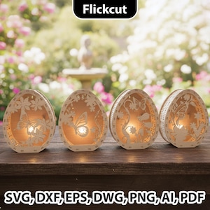 Op de afbeelding: Vier houten eivormige lantaarns met ingewikkelde vlinder- en bloemuitsparingen. Elke lantaarn heeft een warm, gloeiend licht van binnen. De lantaarns staan op een houten oppervlak met een vage tuinachtergrond.