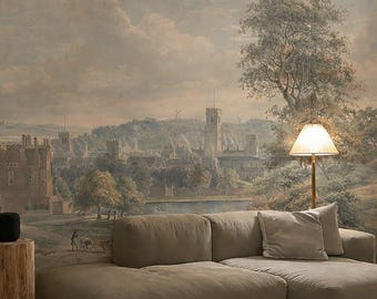 Puede incluir: Un salón con un gran mural paisajístico en la pared. Un sofá seccional beige descansa sobre una alfombra crema con un patrón geométrico negro. Una mesa auxiliar de madera sostiene un altavoz negro y una lámpara proporciona luz cálida.