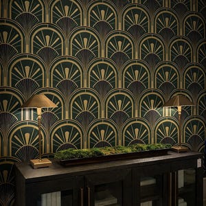 Può includere: Carta da parati Art Déco verde scuro e oro con un motivo a ventaglio ripetuto. Sotto, un mobile in legno scuro con ante in vetro e ferramenta in ottone. Due lampade dorate e una fioriera con muschio sopra.