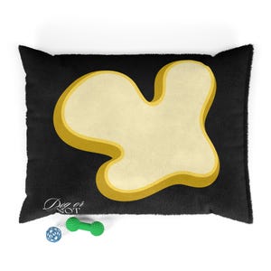 May include: Black dog bed with a large, cream-colored, bone-shaped design outlined in gold. The bed has a plush texture and includes a small blue ball and a green dumbbell-shaped toy. The text "Dog or Not" is printed on the bed.