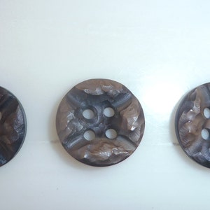 May include: Three brown wooden buttons with four holes each. The buttons have a textured surface and a dark brown color.