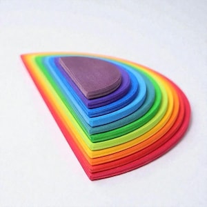 May include: A wooden rainbow stacker toy with a semi-circular design. The toy features layers of vibrant colors, including red, orange, yellow, green, blue, and purple. The stacker is designed to nest together, creating a rainbow arch.