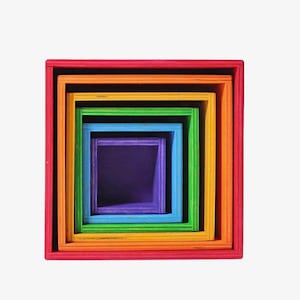May include: Nested set of colorful wooden square boxes in a rainbow of colors. The boxes are arranged inside each other, with the largest box in red and the smallest in purple. The boxes are made of wood.