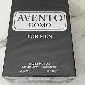K&ouml;nnte beinhalten: Schwarzer rechteckiger Karton mit "AVENTO UOMO FOR MEN" Eau de Parfum. Die Schachtel hat ein silbernes rechteckiges Etikett mit dem Markennamen und Produktnamen. Der Inhalt betr&auml;gt 100 ml.