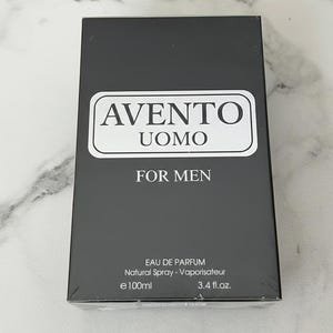K&ouml;nnte beinhalten: Schwarzer rechteckiger Karton mit "AVENTO UOMO FOR MEN" Eau de Parfum. Die Schachtel hat ein wei&szlig;es Etikett mit dem Markennamen und dem Text "FOR MEN". Die Schachtel enth&auml;lt 100 ml Parf&uuml;m.