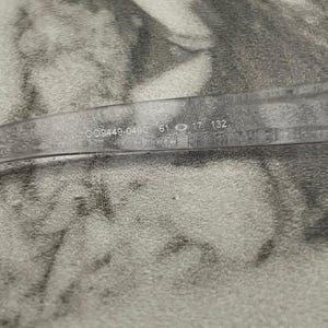 May include: Clear eyeglasses with the numbers "009449-0460 61 17 132" printed on the temple. The glasses are set against a textured, light-colored background.