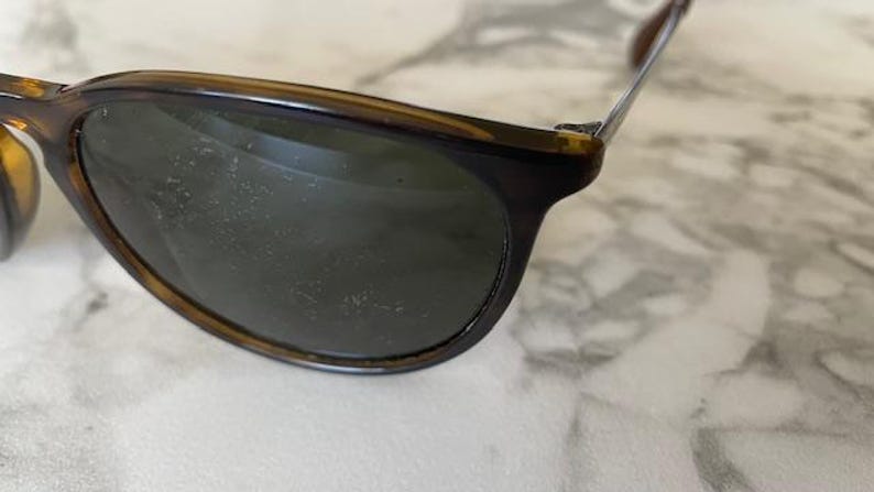 K&ouml;nnte beinhalten: Nahaufnahme einer Sonnenbrille mit dunklen Gl&auml;sern und einem Schildpattrahmen. Die Sonnenbrille hat ein klassisches Design mit einer leicht abgerundeten Form. Der Rahmen ist eine Mischung aus Braun- und Bernsteint&ouml;nen.