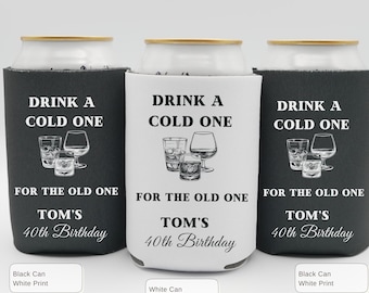 May include: Three can coolers with the text "DRINK A COLD ONE" and "FOR THE OLD ONE". The coolers are black and white with the text "TOM'S 40th Birthday". Each cooler has a different color scheme: black with white print, white with black print, and black with white print.