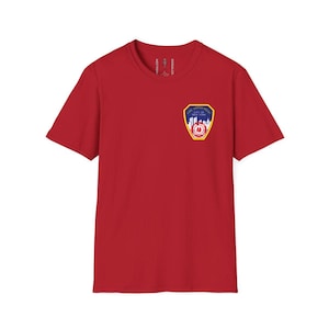 May include: A red crew neck t-shirt featuring a colorful patch on the left chest. The patch displays the text "Fire Department City of New York" with a cityscape and a fire department emblem.
