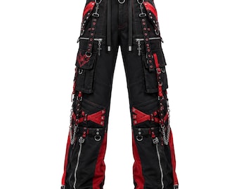May include: Black cargo trousers featuring red fabric panels, multiple silver-tone zips, metal D-rings, and adjustable straps. The trousers include decorative cross charms hanging from the pockets, red embroidery on the thigh, and silver chains.